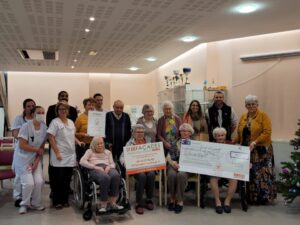 Groupe de personnes tenant des pancartes et un grand chèque de 01 Façades