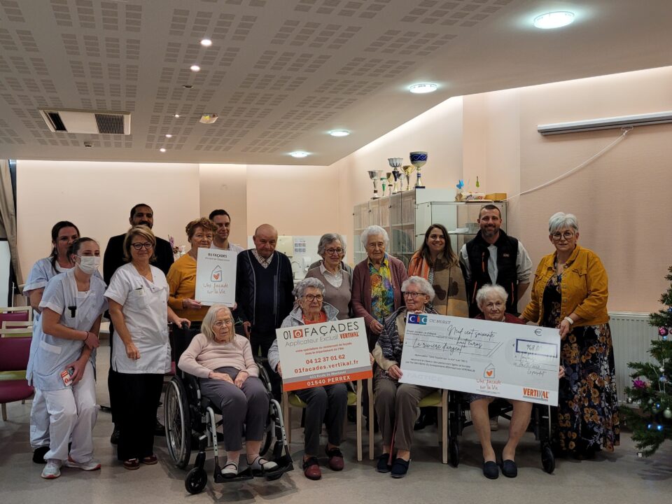 Groupe de personnes tenant des pancartes et un grand chèque de 01 Façades